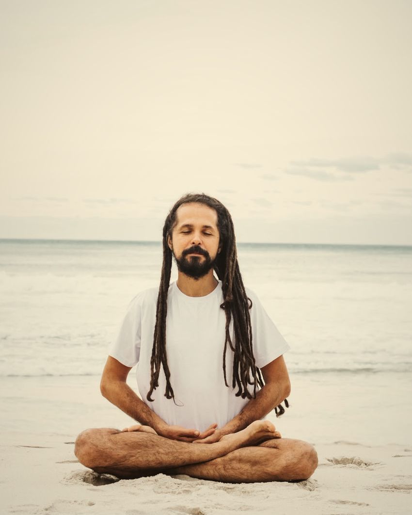 Douglas sentado de pernas cruzadas, olhos fechados, respirando